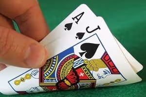 Hand holding a Blackjack hand: Ace of Spades and Jack of Spades