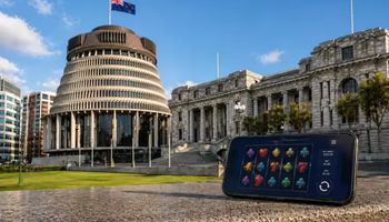 Mobile phone showing online casino game in front of New Zealand Parliament Beehive building representing new online gambling law