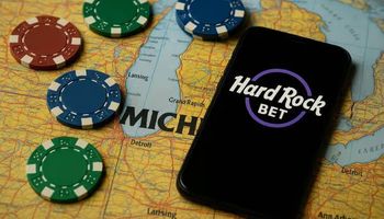 Smartphone showing the Hard Rock Bet logo on a Michigan map with casino chips, representing the sportsbook and online casino launch in the state. If you'd like alternative versions (more casino-focused, more sportsbook-focused, shorter, longer, more keyword-rich), I can generate those too.