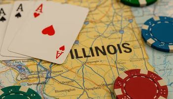 A realistic close-up photograph of poker chips and playing cards placed over a detailed map of Illinois.