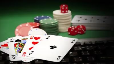 Poker cards on a keyboard and casino chips with dice