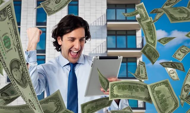 Excited man with tablet under falling dollar bills