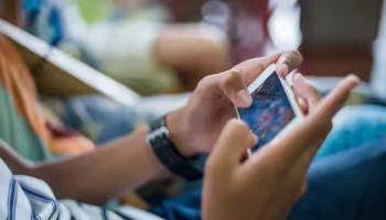 Woman holding a phone playing a social game