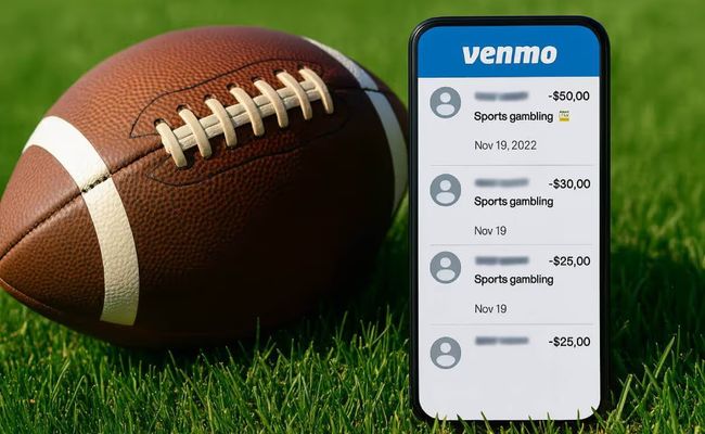 American football on grass next to a smartphone displaying Venmo transactions labeled “sports gambling,” related to NCAA betting rules controversy