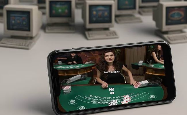 A new online casino on a smartphone displays a live casino game, with old casinos on old computers in the background.